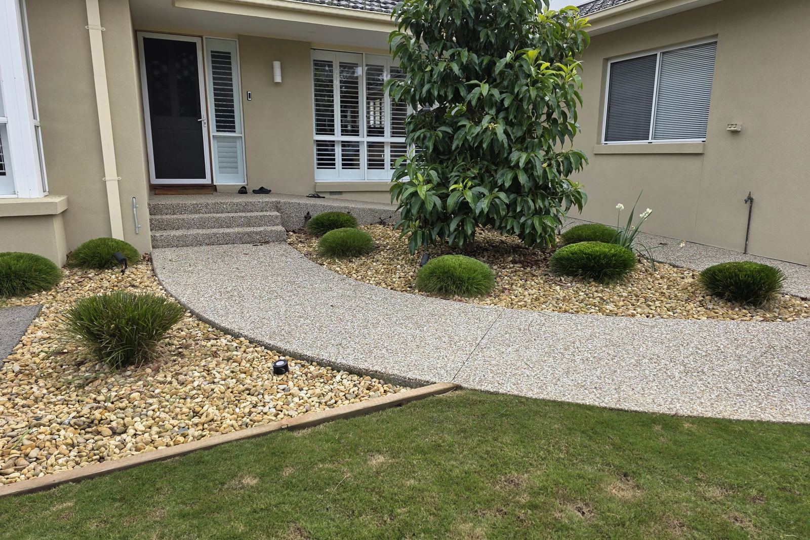 Tidy front garden in Frankston with clipped shrubs, a swept aggregate path and a mown lawn